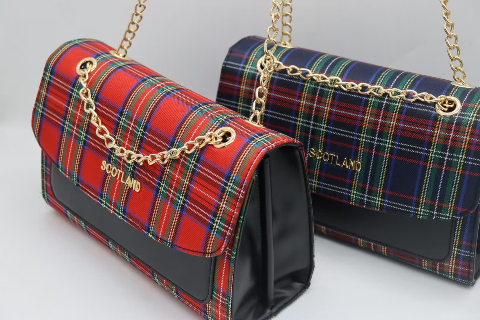 Red and navy tartan chain crossbody bags shown together