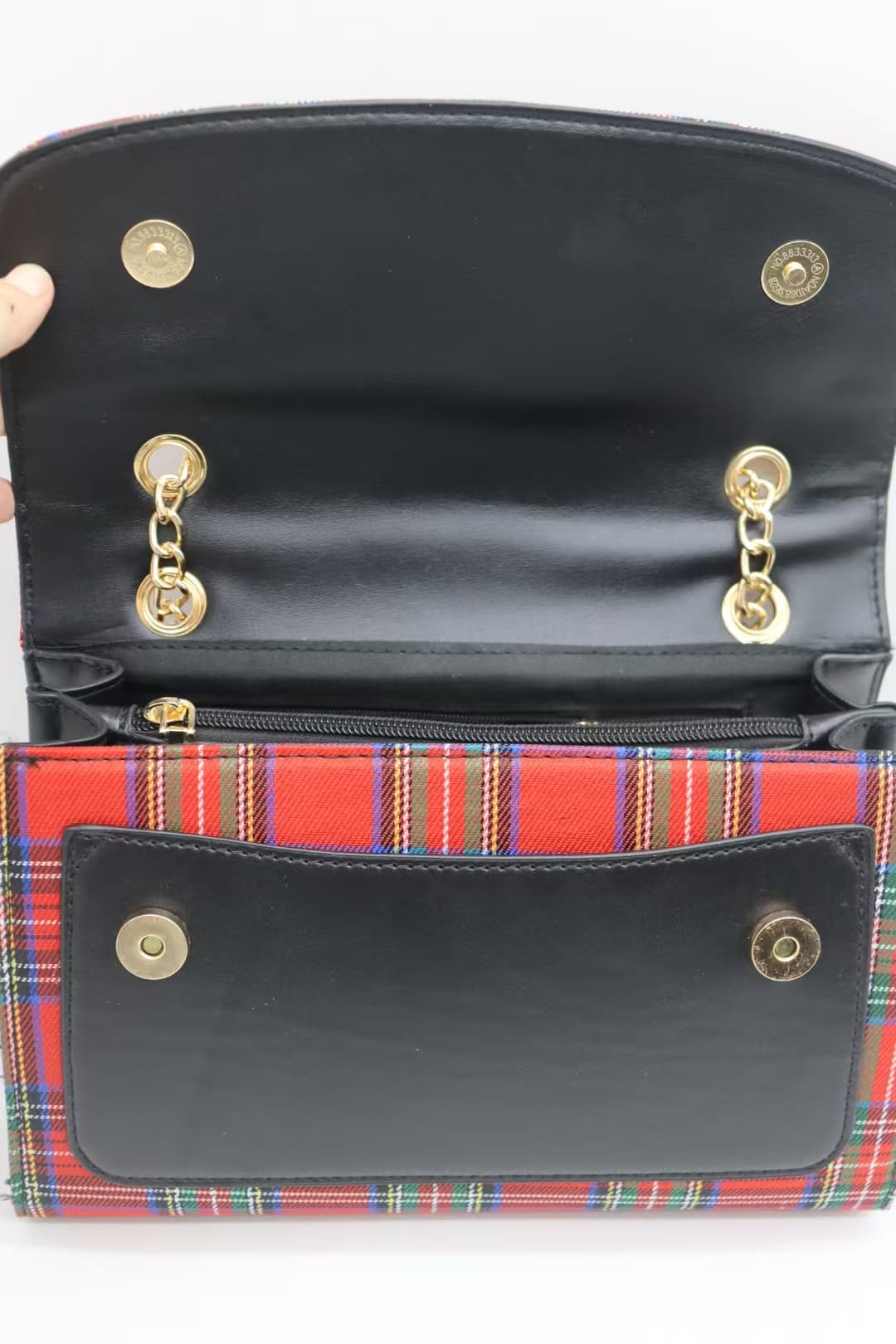 Open red tartan crossbody bag showing magnetic flap and front pocket